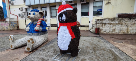 Two teddy bears in Santa Claus hats on the streetの写真素材