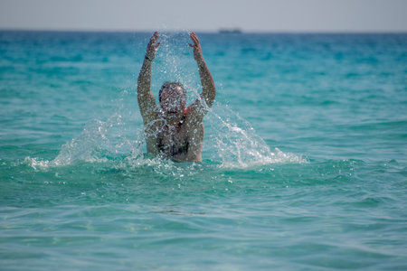 Girl splashing water at the beach on the Caribbean island of Belize