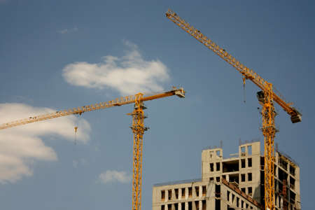 Two construction cranes against the blue skyの写真素材