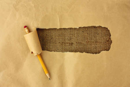 Ripped wrapping paper with a pencil on the background burlapの写真素材