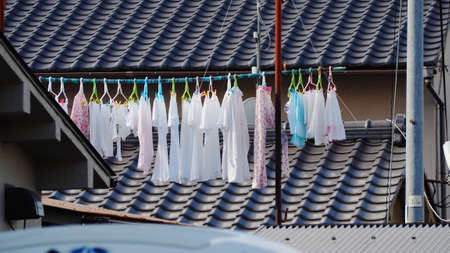 Drying clothes on an outer rail near the roof to receive sunlightの写真素材