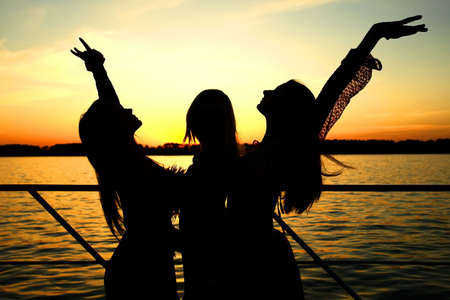 Girls on the sunset background.                               の写真素材
