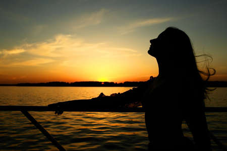 Girl on the sunset background.の写真素材