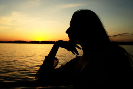 Girl on the sunset background.の写真素材