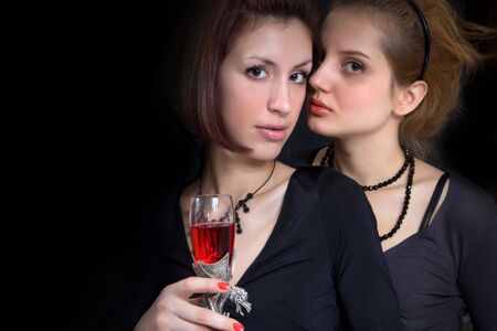 Two pretty girls with the wineglass of red wine.の写真素材