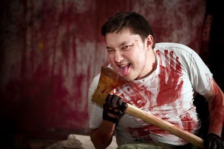 Spooky maniac with axe on the bloody wall background.の写真素材