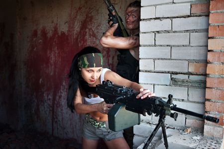 Aiming soldier with the light submachine gun on the bloody wall background.の写真素材