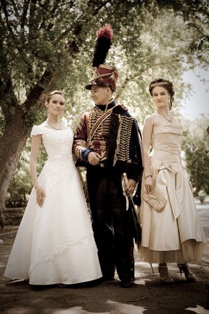 Russian hussar in vintage outfit with two pretty women.