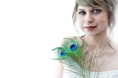 Pretty bride with the peacock feathers. Portrait in high key. Focus point on the face.の写真素材