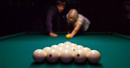 Man and woman are playing billiard. Focus point on the balls.の写真素材