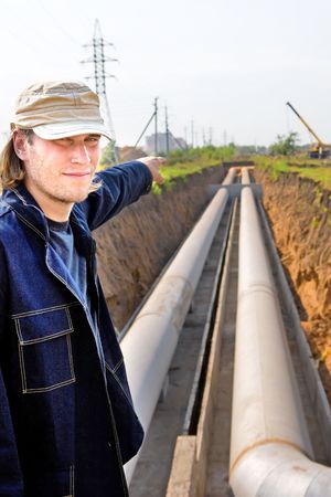 Portrait of an attractive industrial worker on the trunk pipeline backgroundの写真素材