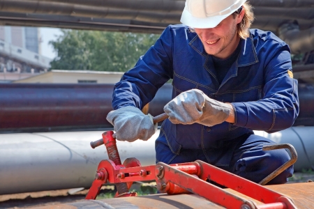 Yong worker in uniform is construction the trunk pipeline