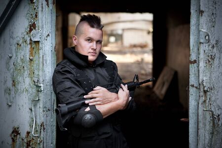 Warrior with the M4 rifle on the ruined building background.