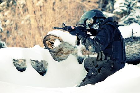 NATO soldier in winter uniform with the M4 machine gun on the forest background.の写真素材