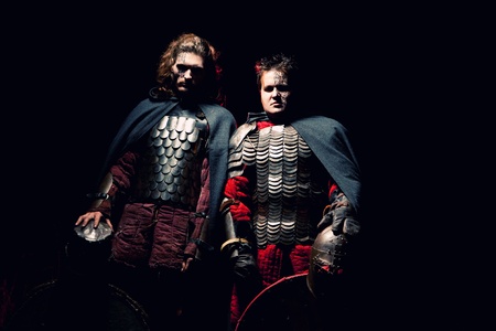 Powerful knights in the armor with the helmets. Dark background.の写真素材
