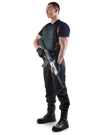 Police officer in body armour is holding a gun. Isolated on white.の写真素材