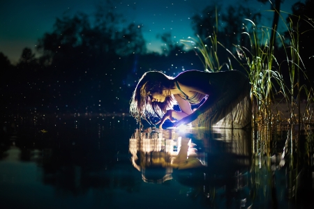 Attractive witch is looking on the shiny water in the riverの写真素材