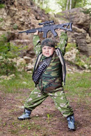 Yong hunter with the rifle is posing on the forest  の写真素材