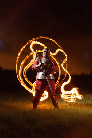 Medieval knight in the armor with the sword  Sunset on the background の写真素材