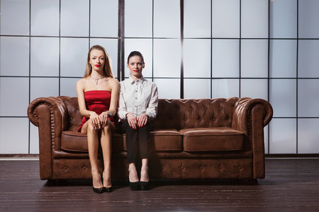 Beautiful girls are sitting on the sofa.の写真素材