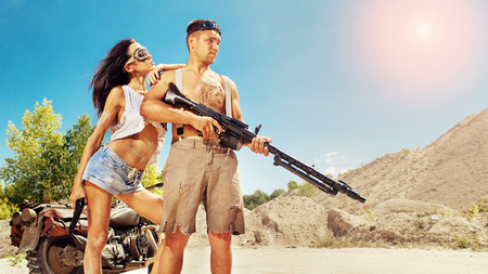 Sexy couple of bikers with guns on the desert background.の写真素材