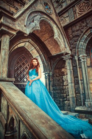 Princess in blue dress is going to open the castle door.の写真素材