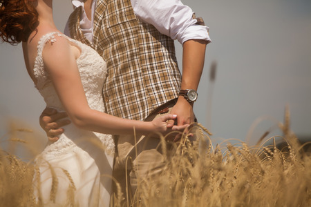 Happy embracing couple on the wheat field background.の写真素材