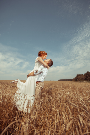 Happy embracing couple on the wheat field background.の写真素材