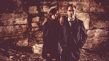 Couple of well dressed peolpe on the dark rocks background.の写真素材