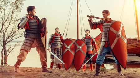 Battle of two medieval knights with swords and shields. Other knights on the background.の写真素材