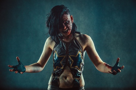 Furious zombie woman with the blood on the face and hands.の写真素材