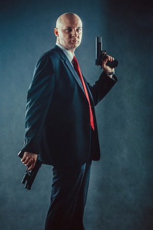 Bald man in business suit with the guns.の写真素材