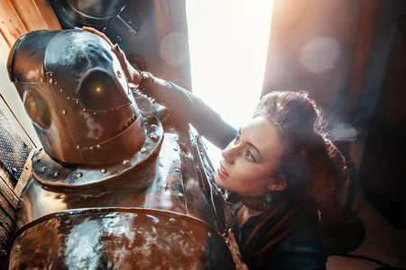 A beautiful woman embracing male robot with love. Relationship between artificial cyborg and real girl. Closeup portrait of futuristic couple.の写真素材