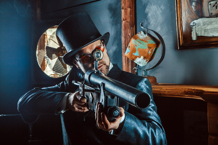 Mature gentleman with a rifle on the dark room background.の写真素材