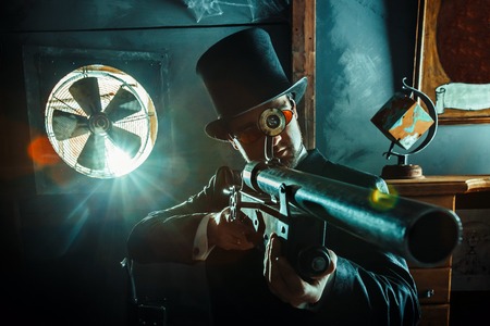 Mature gentleman with a rifle on the dark room background.の写真素材