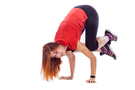 Beautiful woman is standing on hands, holding legs in air. Isolated over white backgroundの写真素材