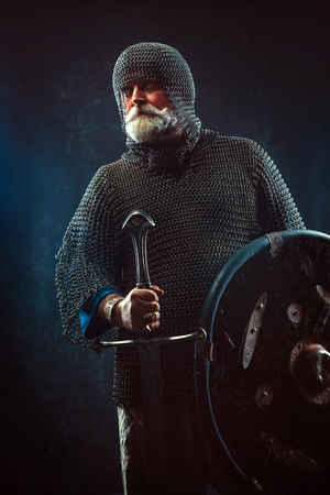 Powerful bearded knight with the sword on the dark backgroundの写真素材