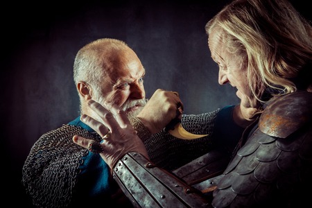 Dagger fight between two medieval knights on the dark background