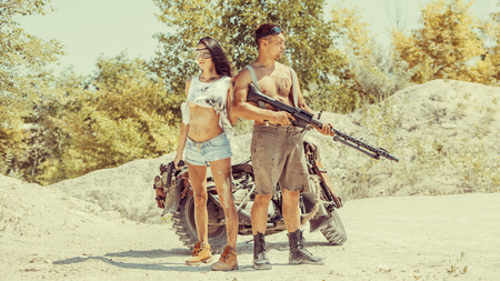 Sexy couple of bikers with the guns on the desert background.の写真素材