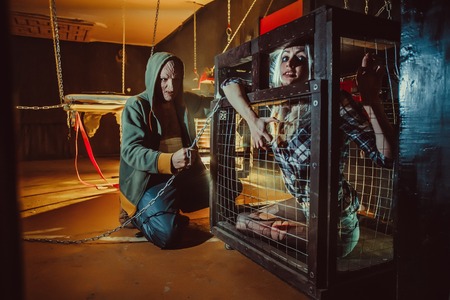 Bloody maniac and his female victim in the cage.の写真素材