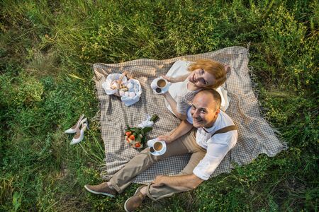 Attractive Couple Enjoying Romantic Sunset Picnic in the Countrysideの写真素材
