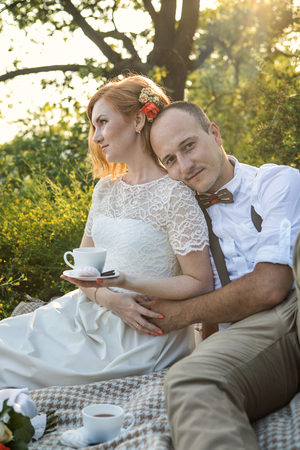 Attractive Couple Enjoying Romantic Sunset Picnic in the Countrysideの写真素材
