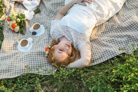 Attractive Woman Enjoying Romantic Sunset Picnic in the Countrysideの写真素材