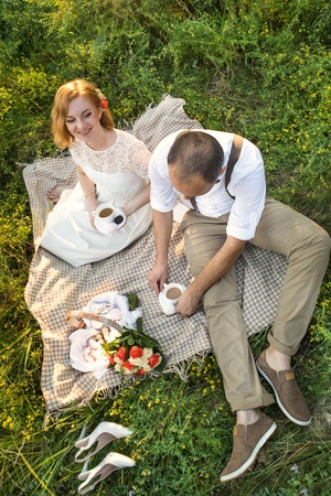 Attractive Couple Enjoying Romantic Sunset Picnic in the Countrysideの写真素材