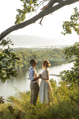 Attractive couple enjoying romantic sunset on the top of the hill.の写真素材