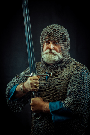 Powerful bearded knight with the sword on the dark backgroundの写真素材