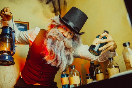 Bearded man wearing black hat and vest with the lantern. Medicine man in Dickens style.の写真素材