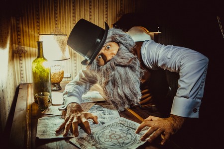 Bearded man reads a mysterious letter in the dark room