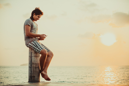 Man is relaxing on the pierce watching the sea.の写真素材