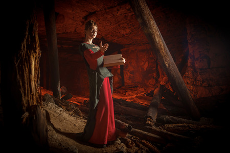 Beautiful young witch with the spellbook.の写真素材